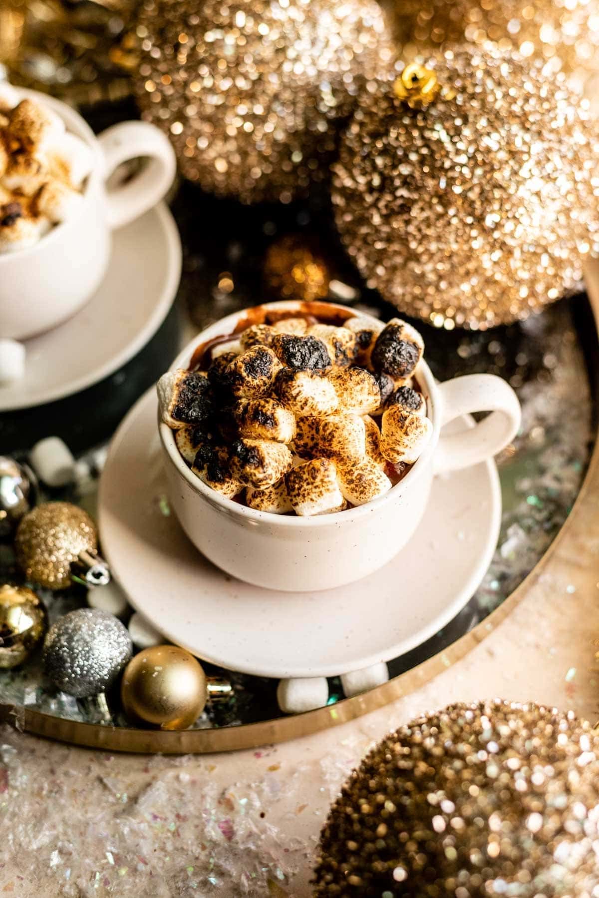 bourbon-spiked-french-hot-chocolate Drink in white mug topped with torched marshmallows on a festive table.