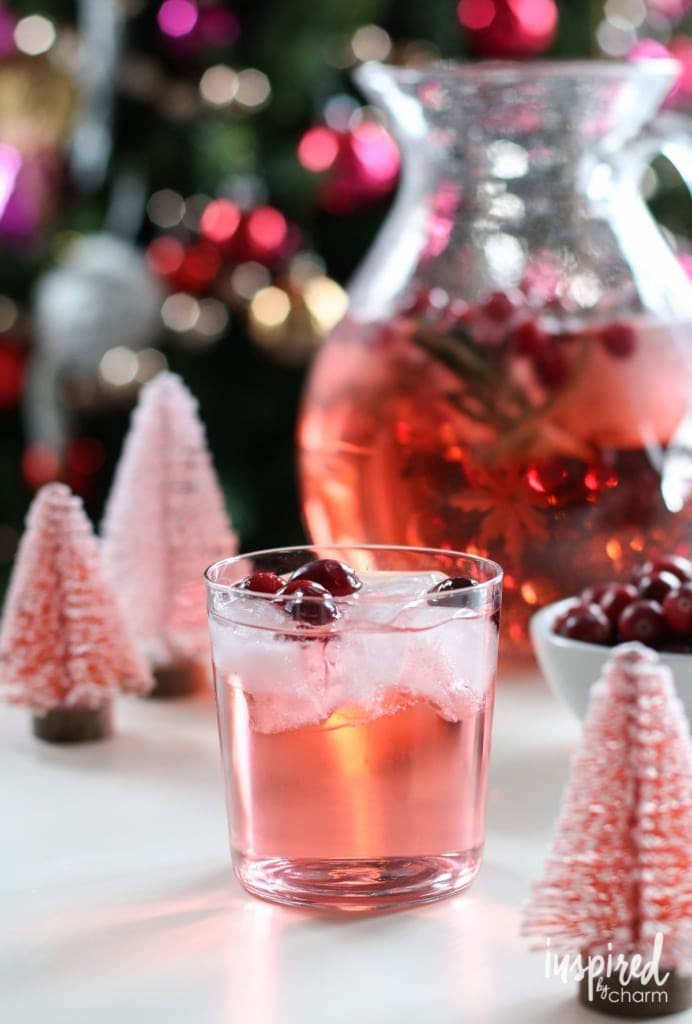 christmas-cocktails A glass of pink cocktail with ice and cranberries.