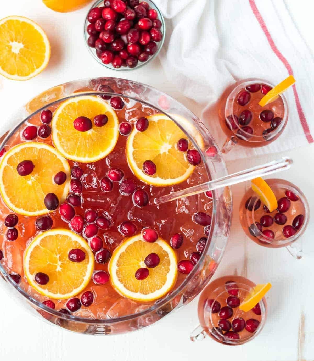 christmas-punch Christmas punch on a huge glass bowl with plenty of ice, fresh cranberries, and orange slices.