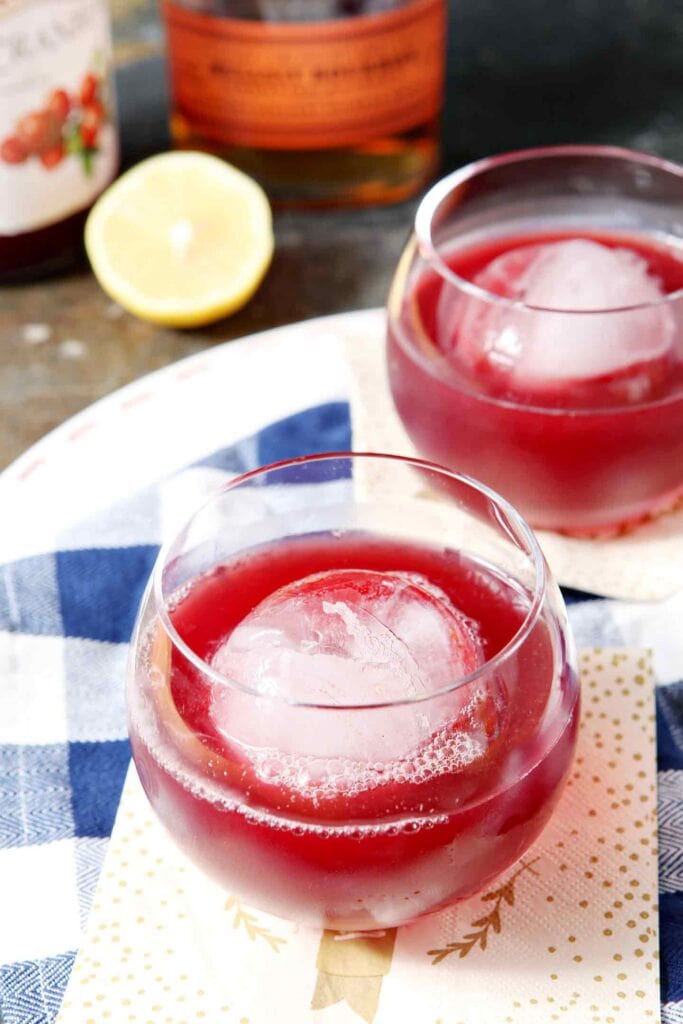 cranberry-bourbon-cocktail-683x1024-1 Cranberry cocktail with ice ball on a bourbon glass.