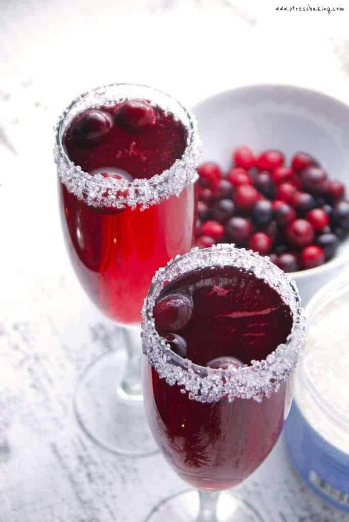 cranberry-mimosa-1 Two glasses of cranberry margarita with a bowl of cranberries.