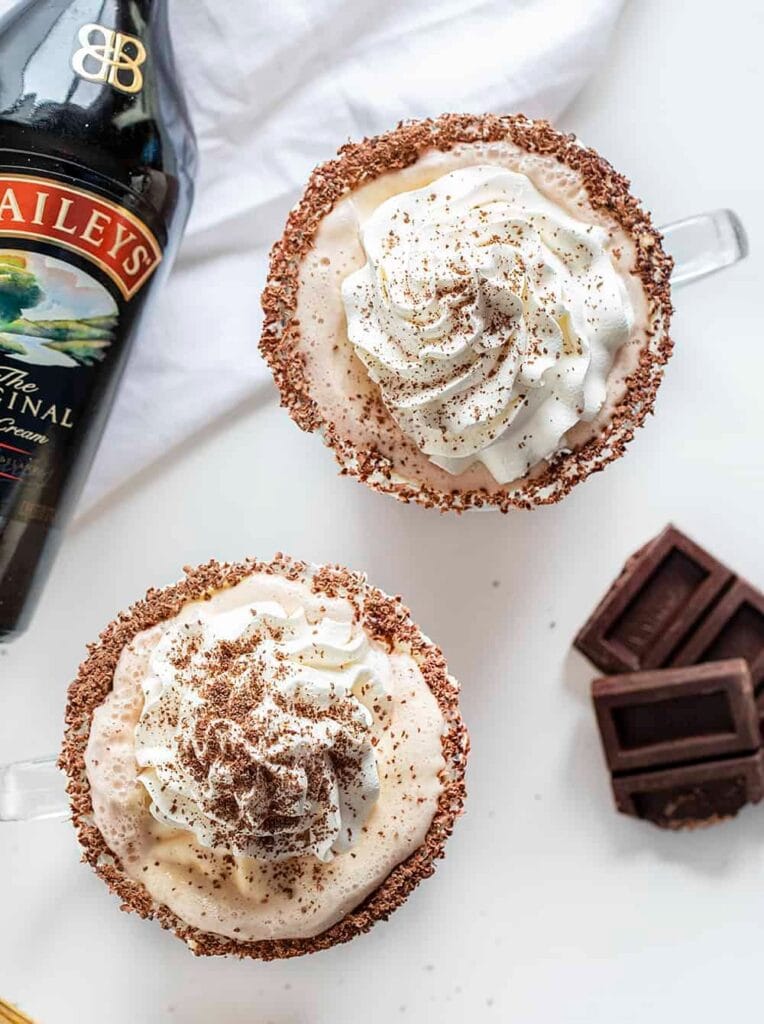 drunk-snowman-764x1024-1 Chocolate rimmed cocktail topped with whipped cream and a sprinkle of cocoa powder and a bottle of Bailey's beside.