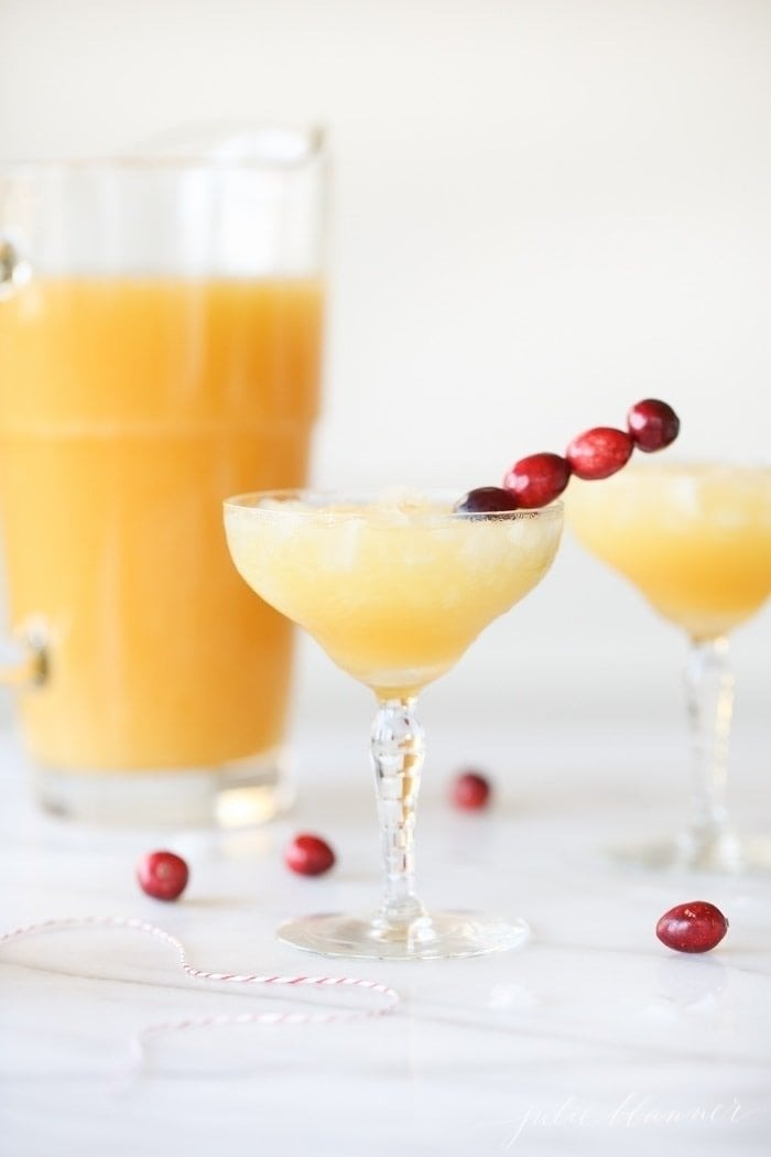 holiday-mai-tai Iced pineapple cocktail in glasses garnished with grapes on stick.
