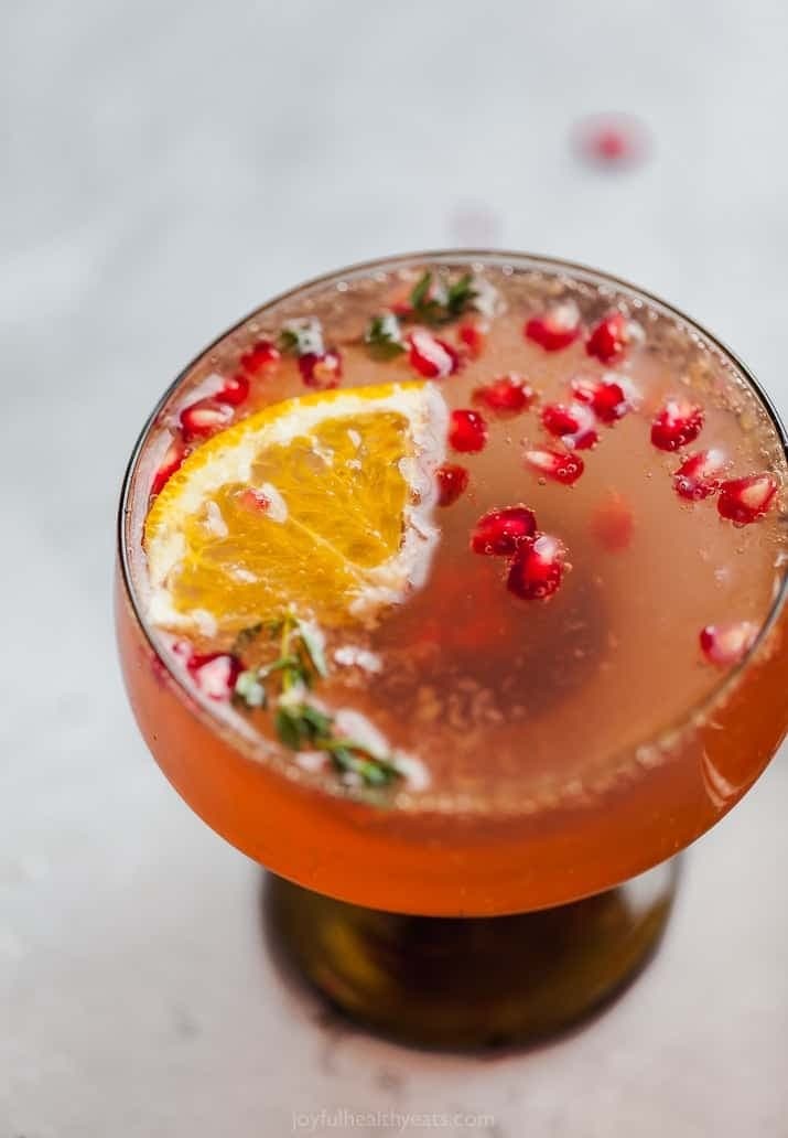 holiday-pomegranate-gin-cocktail A cocktail with orange slices and pomegranate garnish.