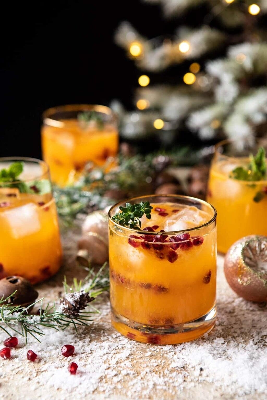 holy-jolly-christmas-citrus-cocktail A glass of citrusy vodka cocktail garnished with pomegranate seeds.