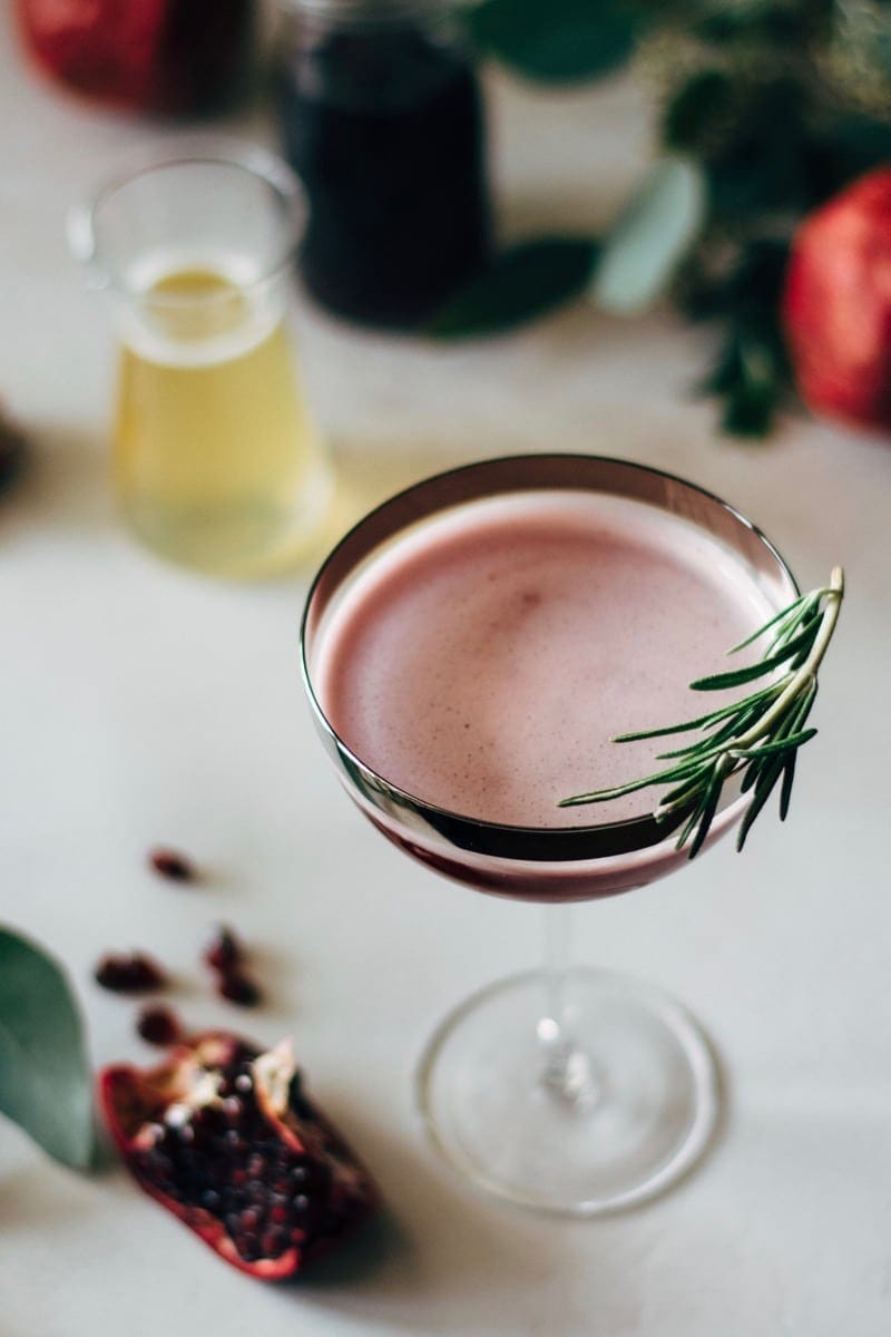 pomegranate-martini-with-rosemary-honey-syrup Pomegranate martini with rosemary honey syrup on a cocktail glass.