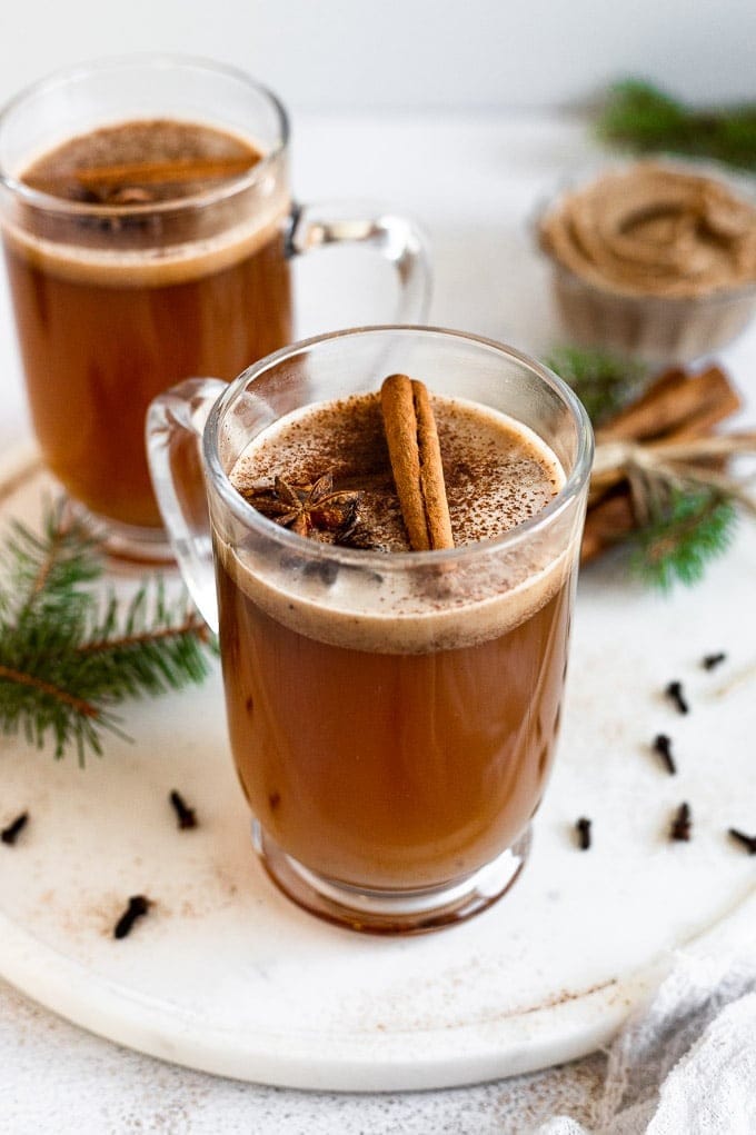 spiced-hot-rhum Spiced rum served on a glass mug garnished with cinnamon powder and stick.