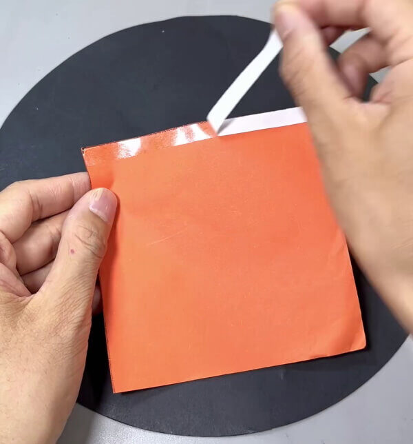Applying Double Side Tape On Orange Square Paper Side - Simple Step-By-Step Guide to Making a Paper Carrot